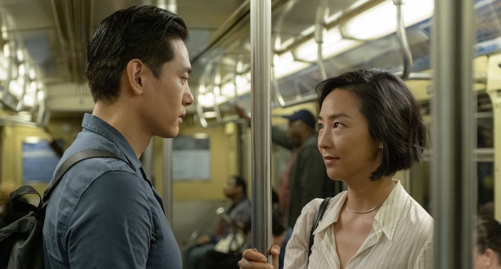Still from "Past Lives" featuring the main characters gazing into each other's eyes on the subway