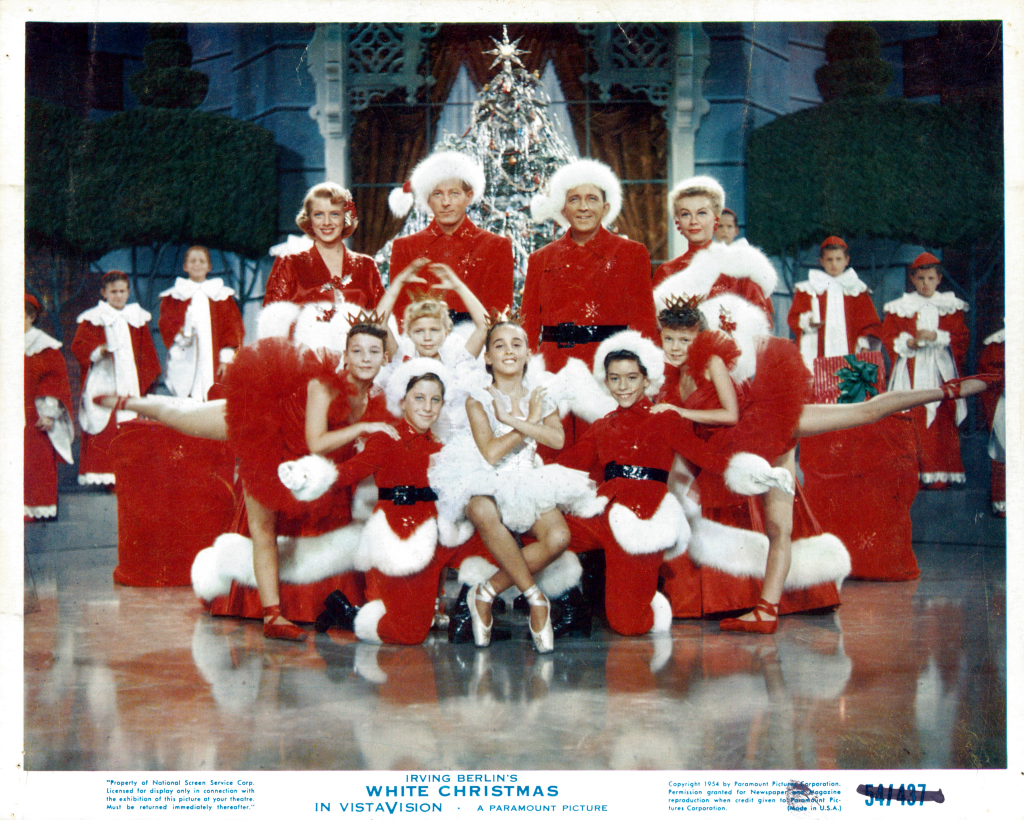 A poster for "White Christmas" featuring a number of cast members dressed in Santa outfits
