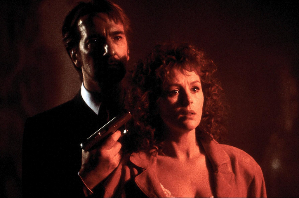 A still from "Die Hard" featuring a man holding a gun to a woman's head