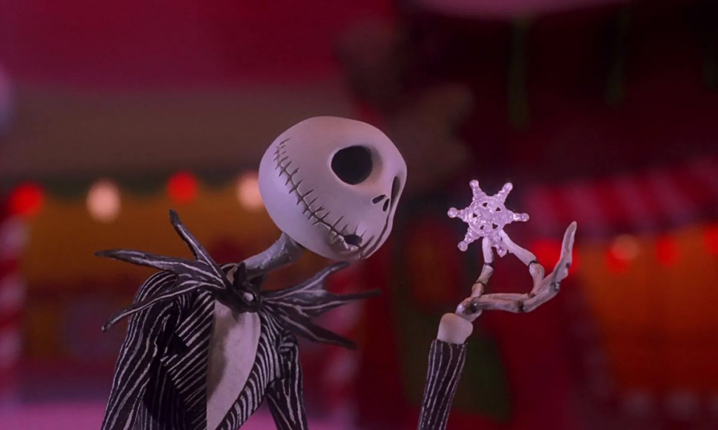 A still from "The Nightmare Before Christmas" featuring the main character, a skeleton in a striped suit, holding up a snowflake