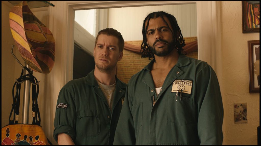 Still from "Blindspotting" featuring two men in mover's outfits staring inquisitively at something off camera
