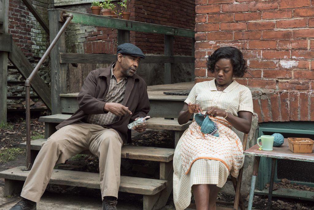 Still from "Fences" featuring a man and a woman sitting on a stoop