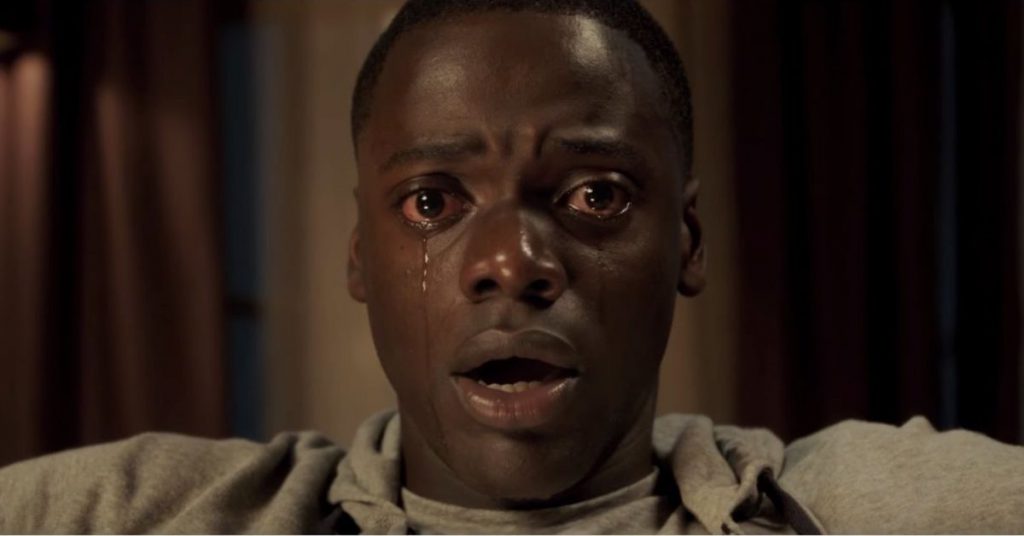 Still from "Get Out" featuring a man staring into the camera with tears streaming down his face