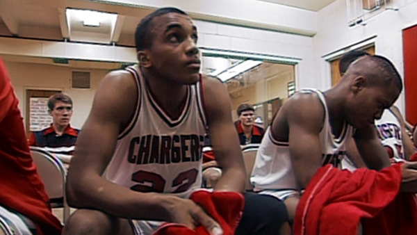 Still from "Hoop Dreams" featuring basketball players sitting in a locker room