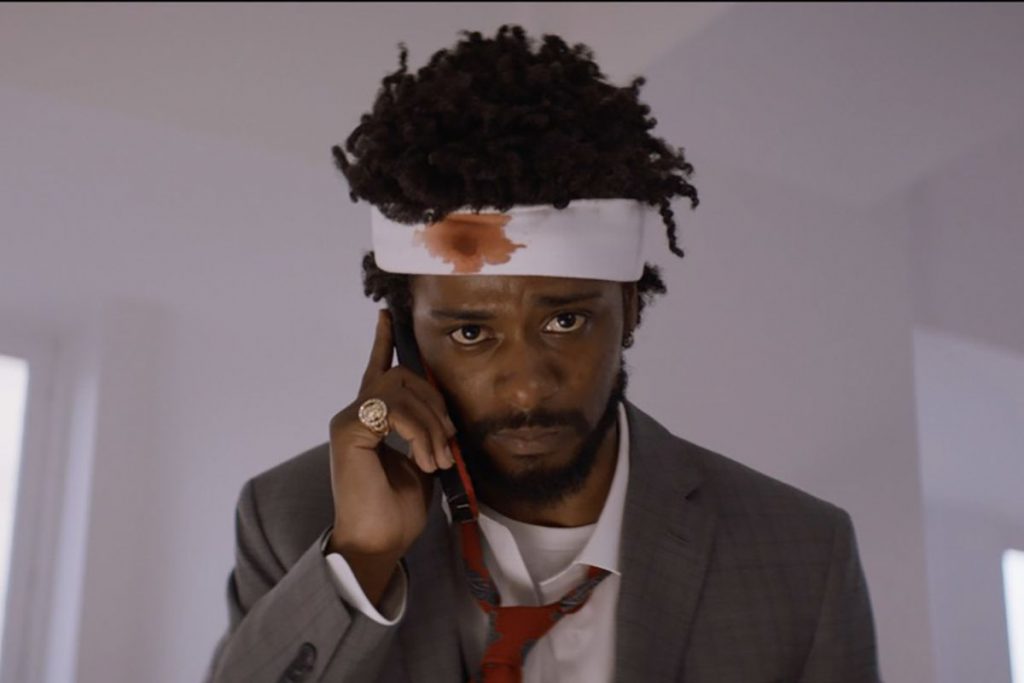 Still from "Sorry to Bother You" featuring a disheveled man with a bloody bandage on his head making a phone call