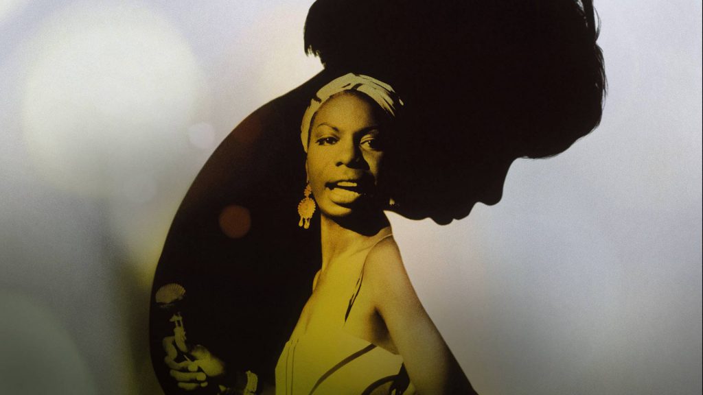 Image for "What Happened, Miss Simone" featuring a shot of Nina Simone holding a microphone inside of a silhouette of Nina bowing her head