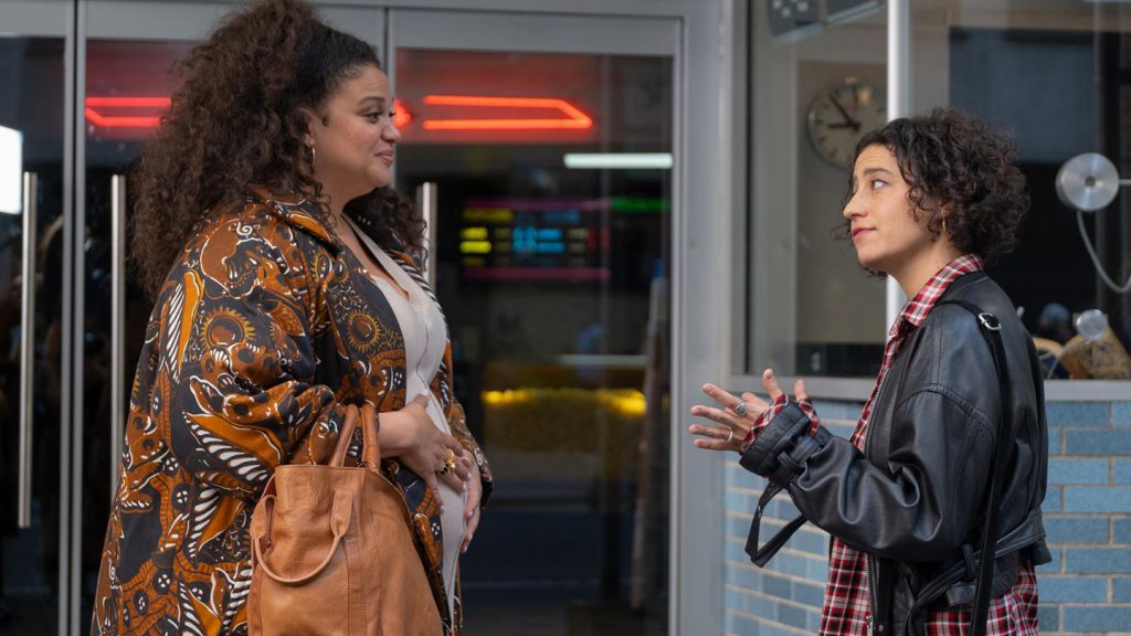 Still from "Babes" featuring two women talking outside a movie theater