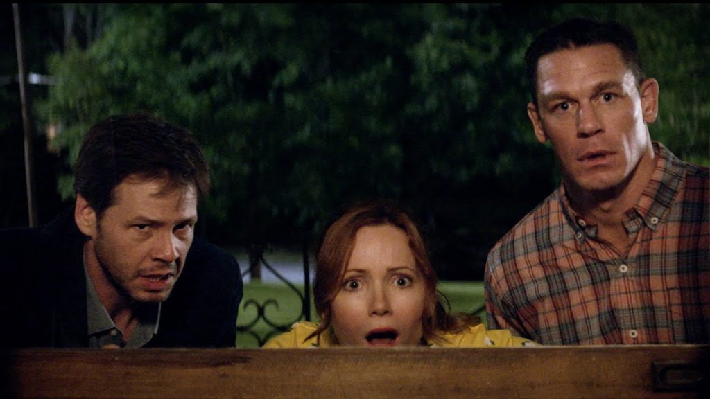 Still from "Blockers" featuring three adults staring shocked through an open window