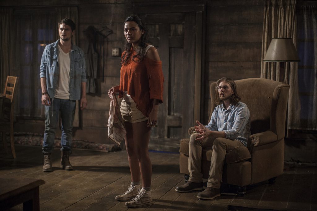 Still from "Evil Dead" featuring three people looking scared in an old home