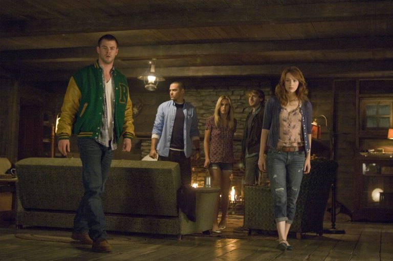 Still from "Cabin in the Woods" featuring a group of teenagers looking scared in a cabin