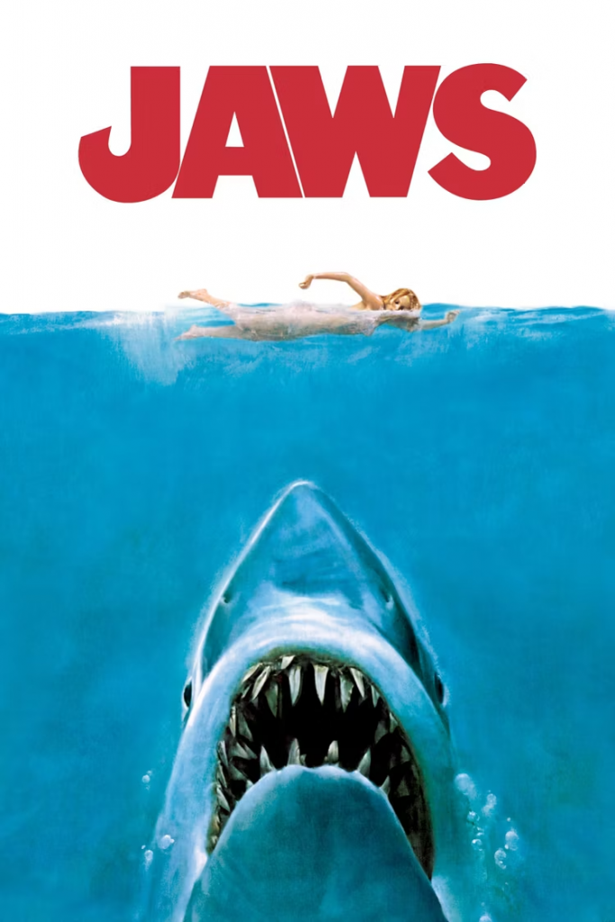 Poster for "Jaws" featuring the title in bright red letters above a naked woman swimming above a massive shark