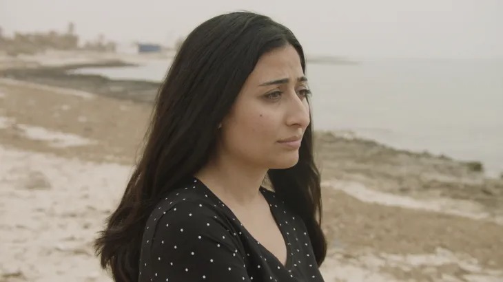 Syrian woman looking out at the sea