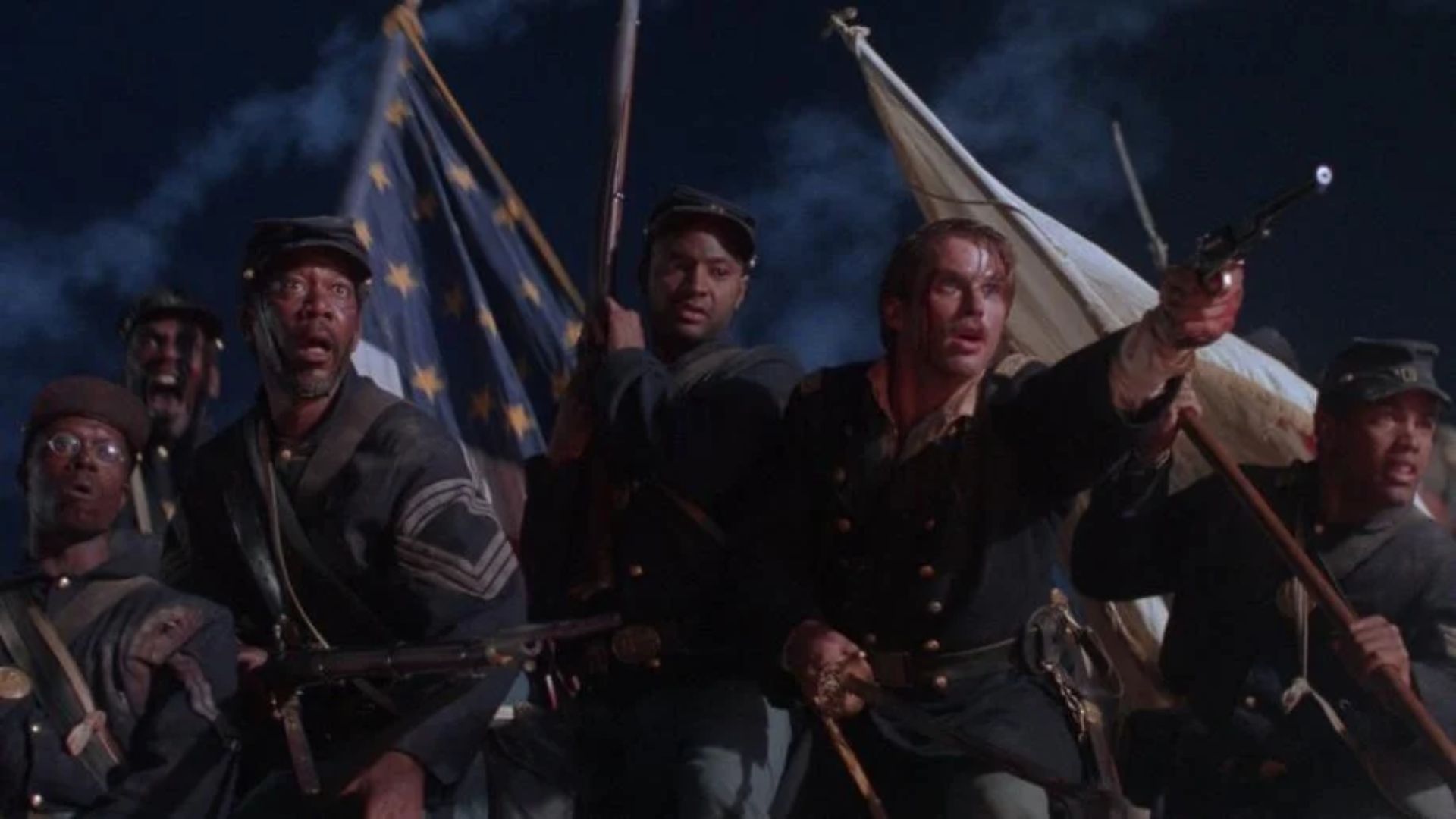 Union soldiers charge forward with flags during a battle scene.