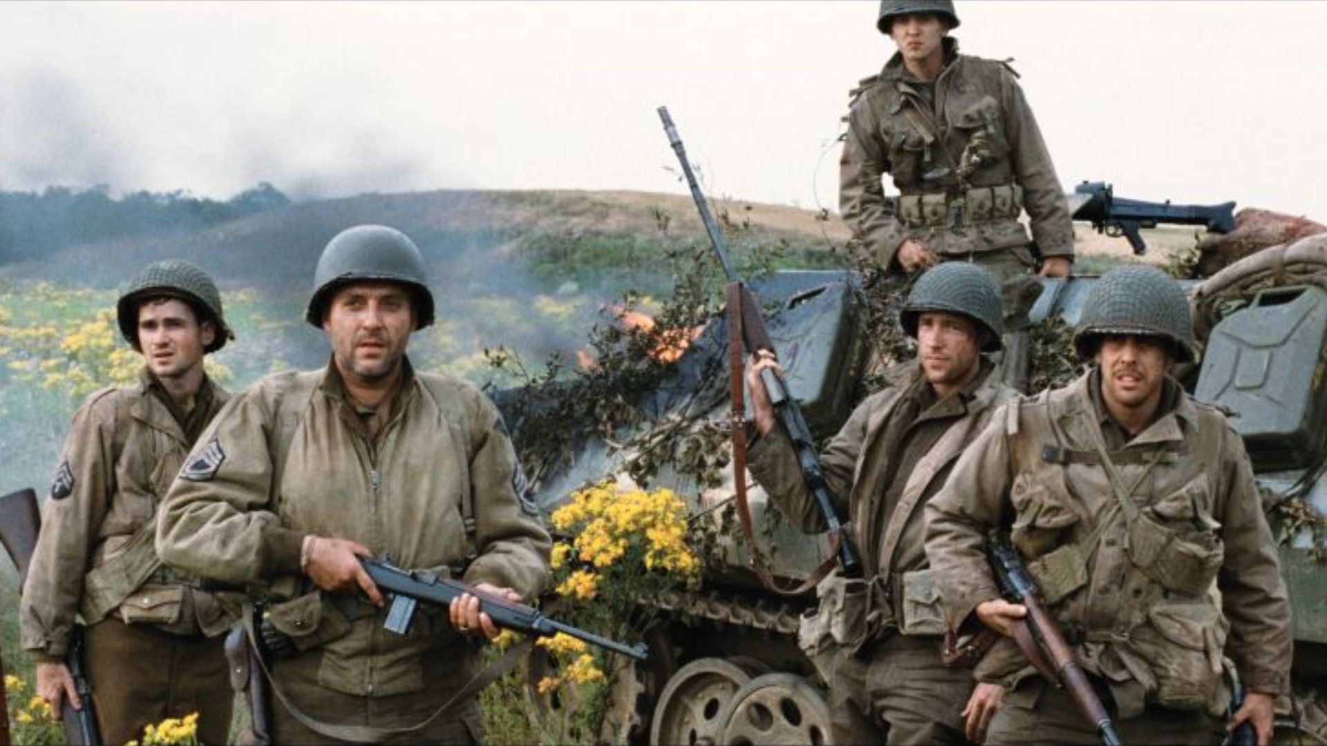 American soldiers stand armed on a battlefield.