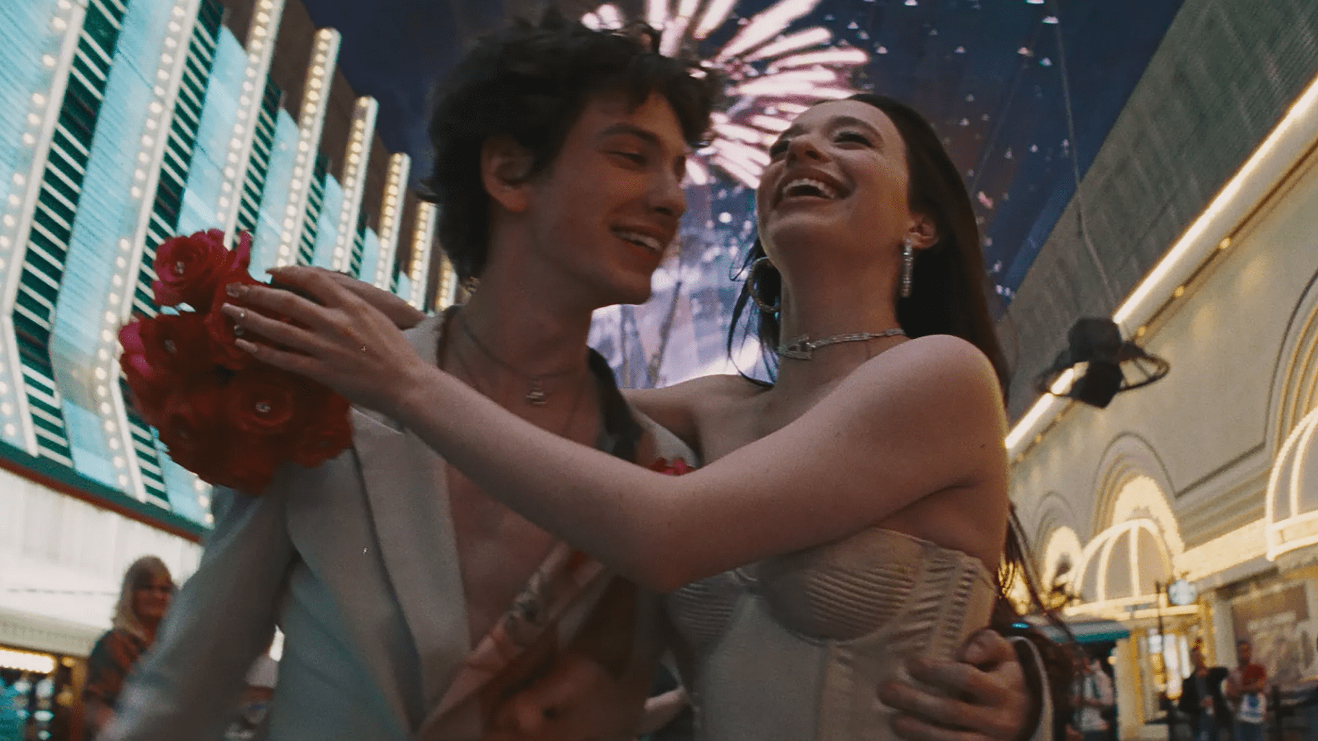 A man and a woman told each other against a bright city at night.