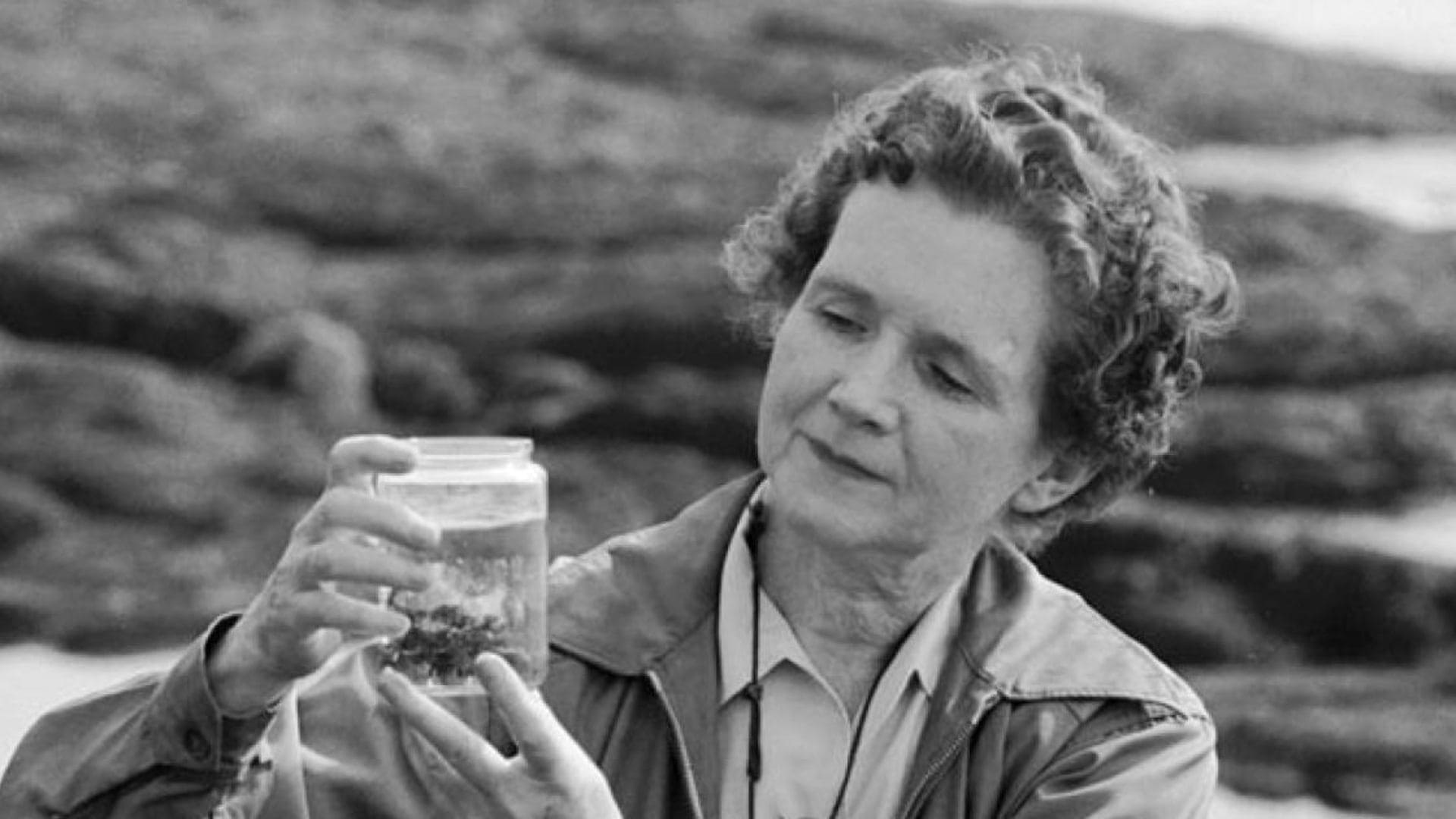 Rachel Carson holds a jar containing a specimen surrounded by liquid.