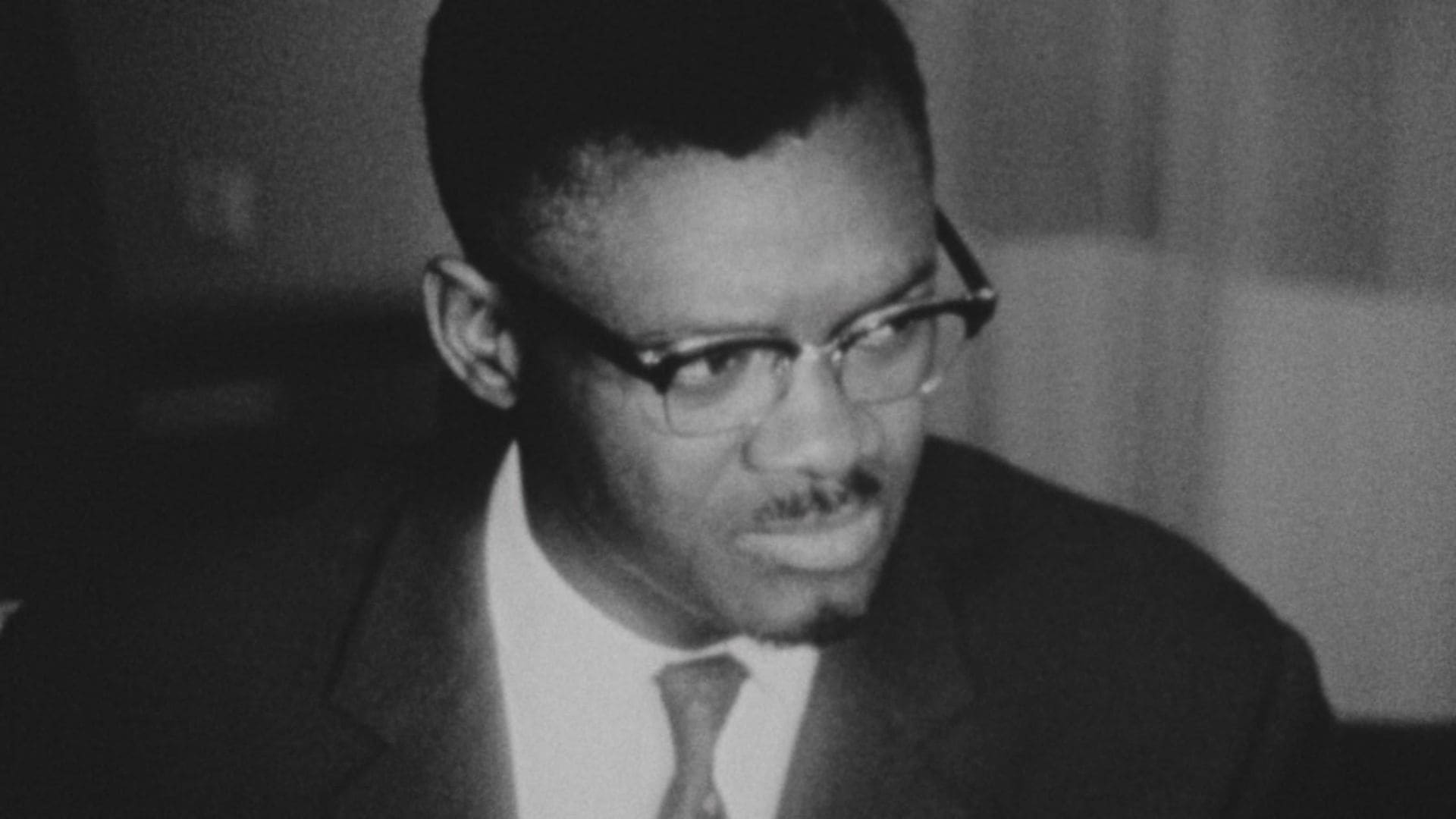 A bust shot of a man in a suit looking away from the camera.