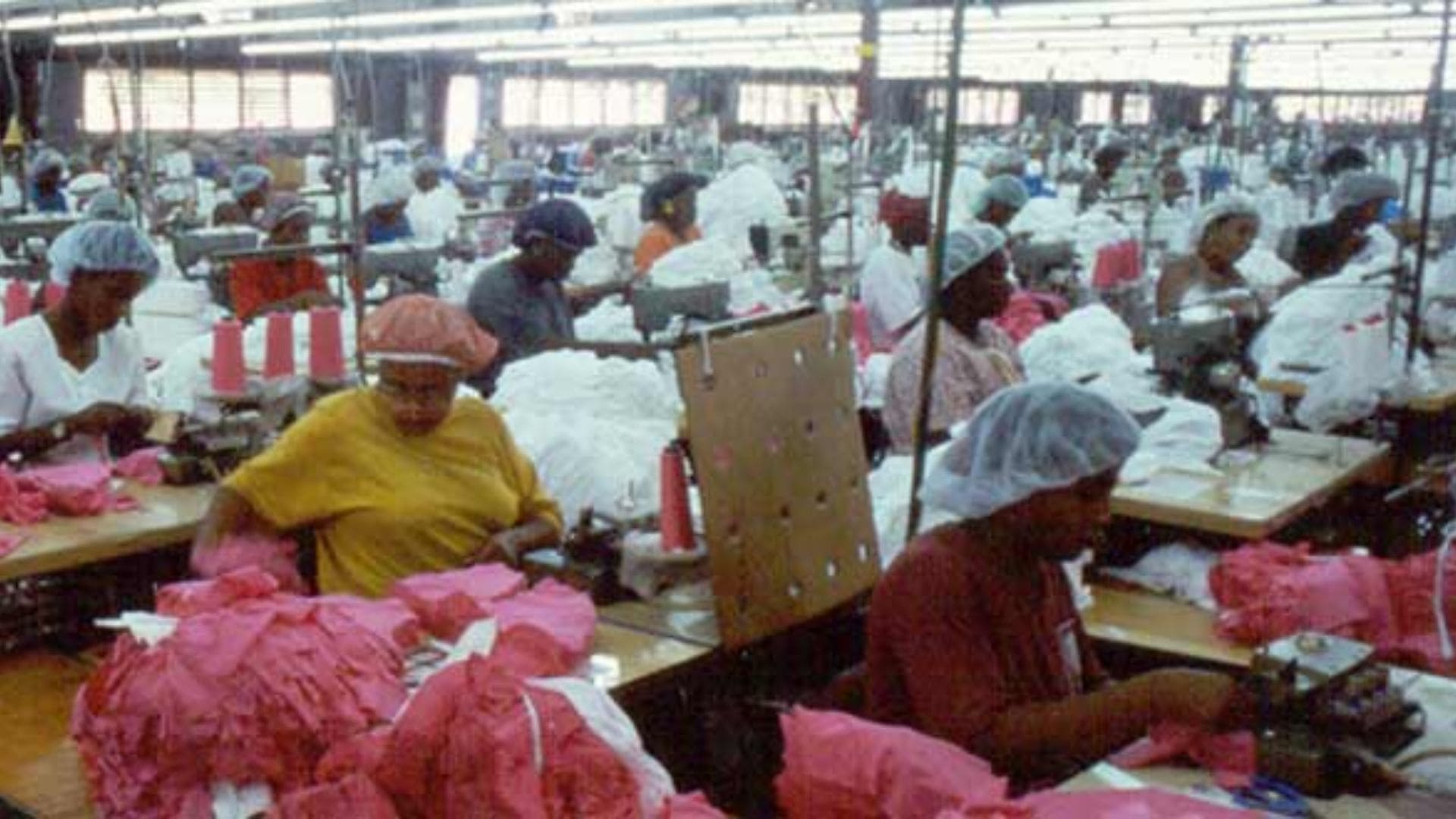 A factory filled with women creating pink garments.