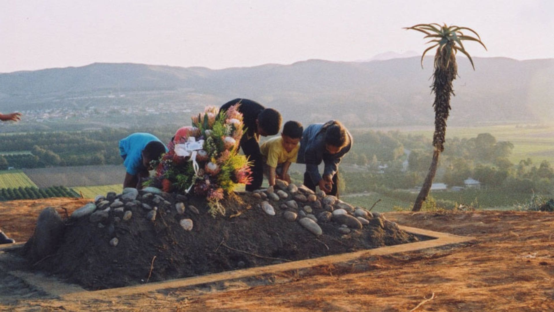 Four figures stand over the burial site of Sara Baartman.