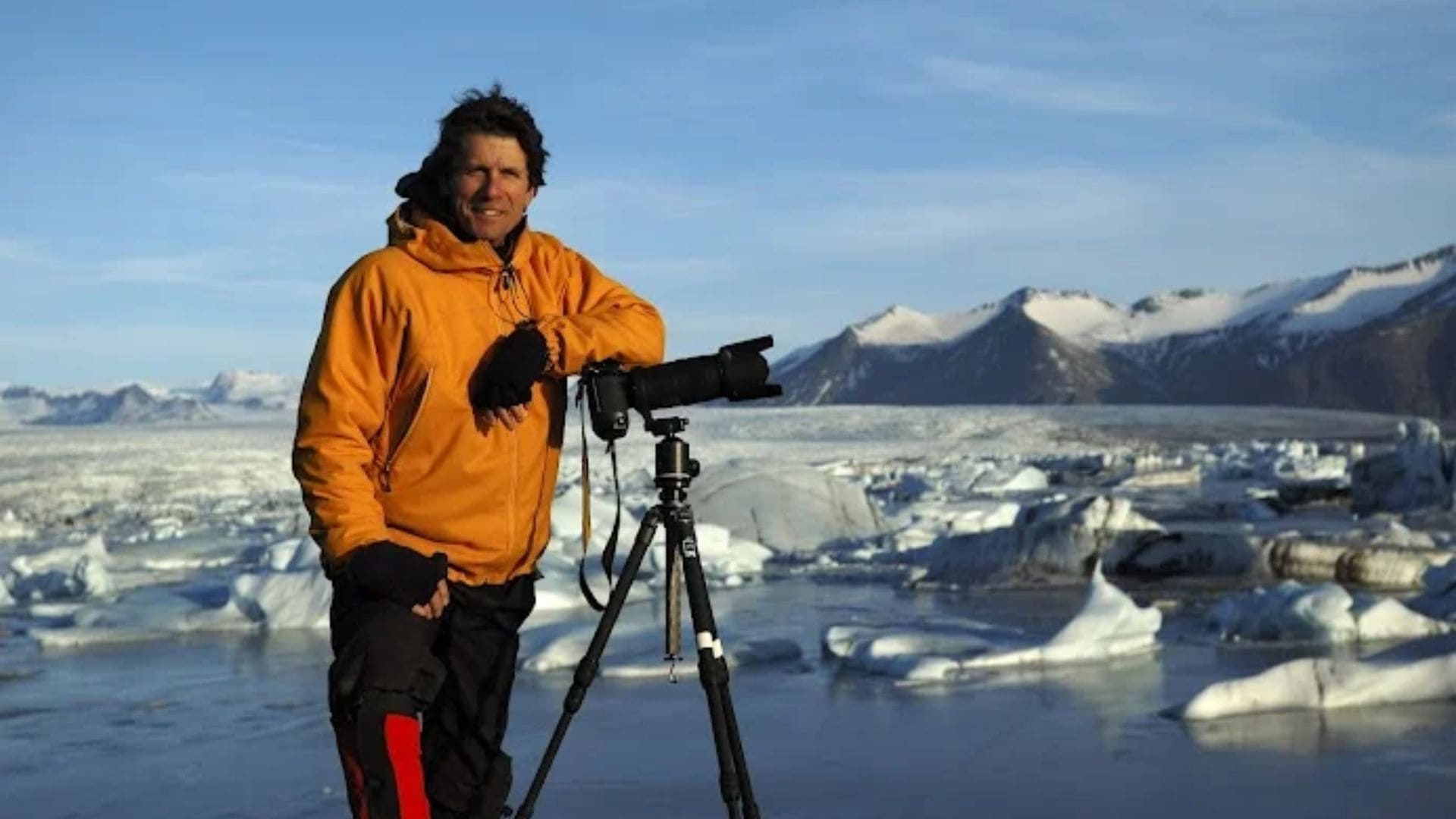A man poses against a camera in a field of glaciers and ice.