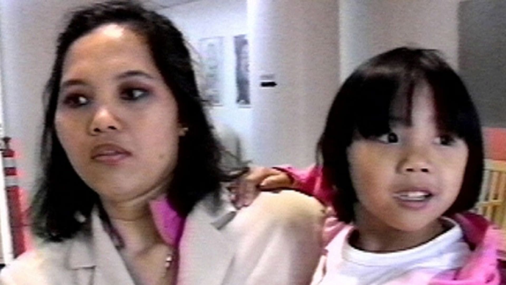 A woman holds a young girl.