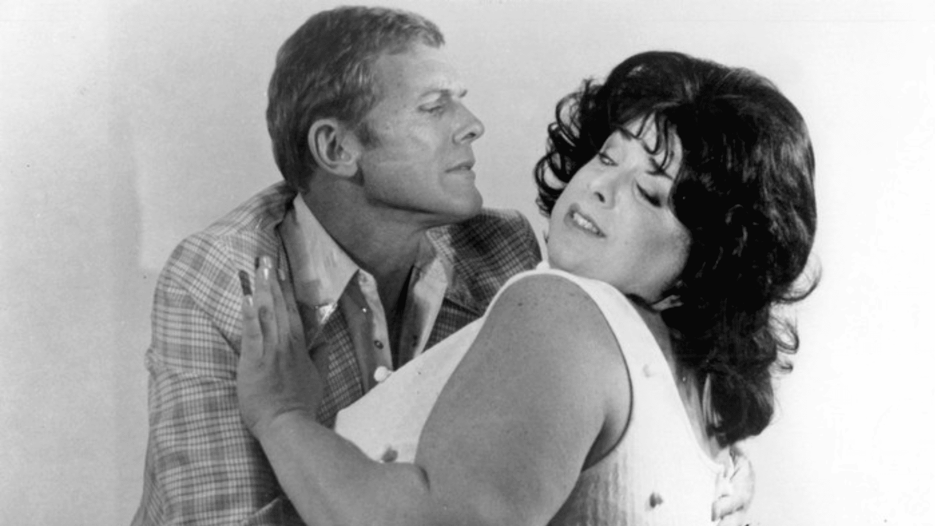 A woman pushes a man away, rejecting his advances.