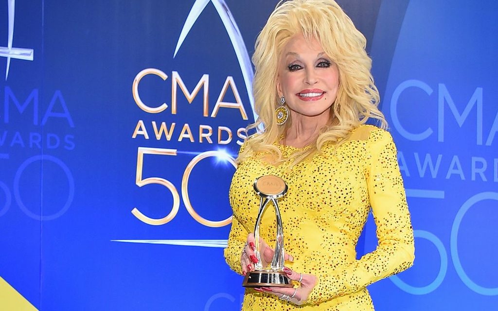 Dolly Parton holding her CMA award